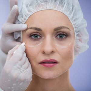 Close-up of doctor marking female patients face for cosmetic treatment